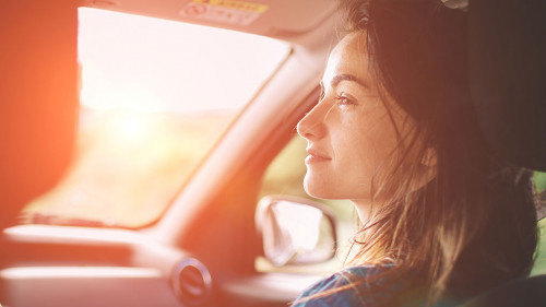 Beautiful woman smiling while sitting on the front passenger seats in the car