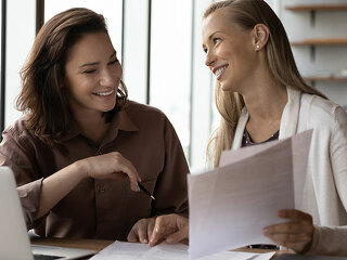 Happy business colleagues analyzing, reviewing project papers