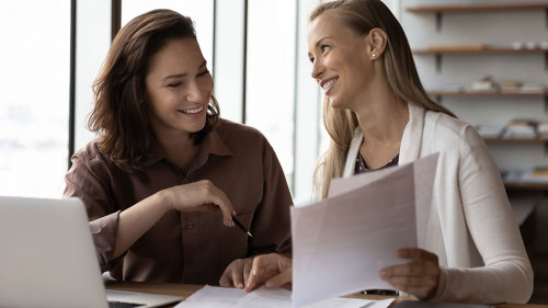 Happy business colleagues analyzing, reviewing project papers