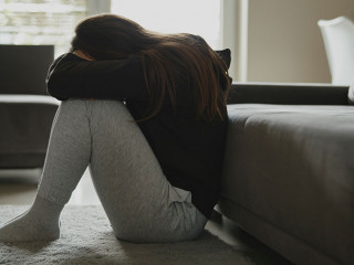 Caucasian broken woman sitting at the floor in living room