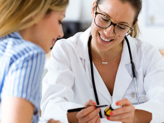 Female doctor prescribing medication for patient.