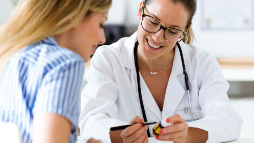 Female doctor prescribing medication for patient.
