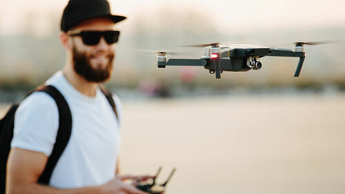 Man operating the drone by remote control and having fun