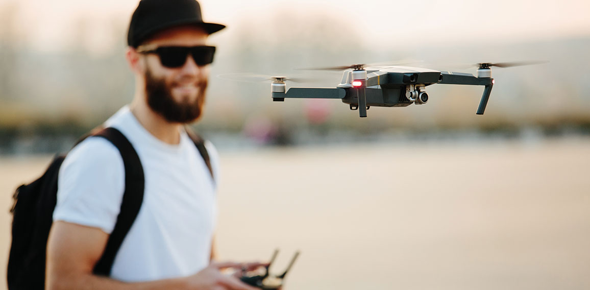Man operating the drone by remote control and having fun