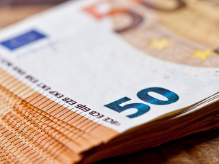 Pile of fifty euro banknotes. Currency notes stacked on rustic w