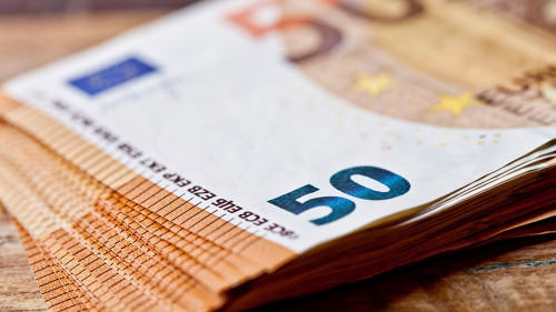 Pile of fifty euro banknotes. Currency notes stacked on rustic w