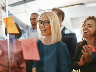 Diverse businesspeople brainstorming with notes on a glass wall