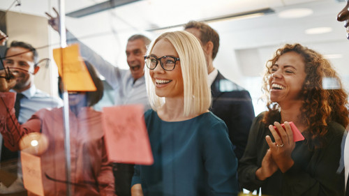 Diverse businesspeople brainstorming with notes on a glass wall