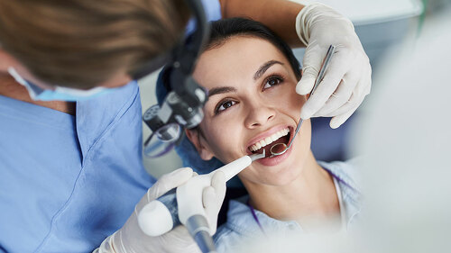 Charming young woman receiving dental treatment at clinic