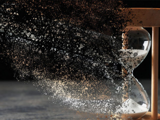 Time is running out. Hourglass vanishing on grey table against b