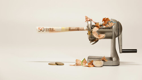 A twisted note in a sharpener with shavings symbolizes inflation