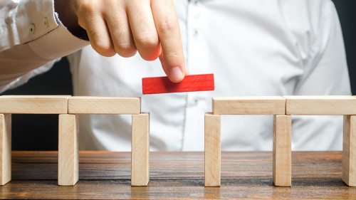 A man is completing the construction of a bridge. Build bridges, make connections and useful contacts. Improving and developing a business. New innovative solutions, growth and prosperity