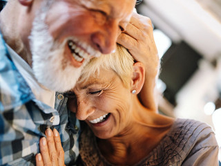 Happy senior couple in love hugging and bonding with true emotions at home