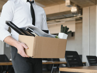 Economist leaving office. Handsome economist leaving the office taking his box with different things