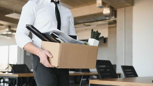 Economist leaving office. Handsome economist leaving the office taking his box with different things