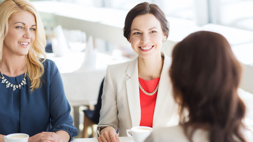 women drinking coffee and talking at restaurant
