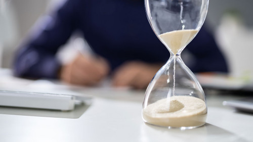 Businessperson's Hand Calculating Invoice In Office