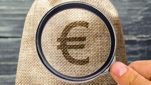 A money bag and a wooden house on the scales. The concept of real estate purchase. Sale of property. Payment of the mortgage. Redemption of taxes. Tax refund. Legacy / Inheritance tax concept