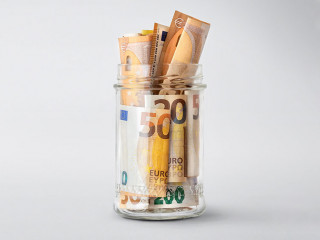 Euro bills in glass jar on a white background with copy space. Saving money concept