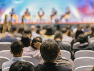 Rear view of Audience listening Speakers on the stage in the con