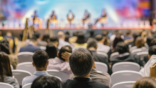 Rear view of Audience listening Speakers on the stage in the con