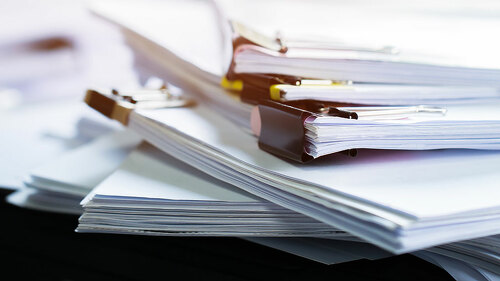 Stack of papers documents in archives files with clip papers on