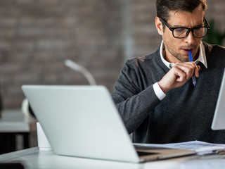 Mid adult businessman using digital tablet while working at his
