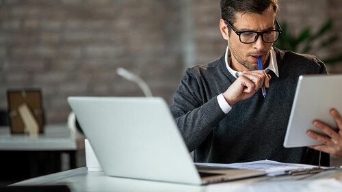 Mid adult businessman using digital tablet while working at his