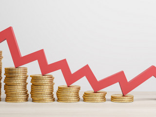 Inflation and global economy crisis concept with red arrow going down on golden coin stacks. 3D rendering