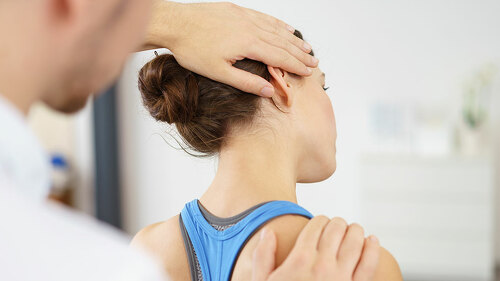 physiotherapeut behandelt eine patientin mit nackenschmerzen