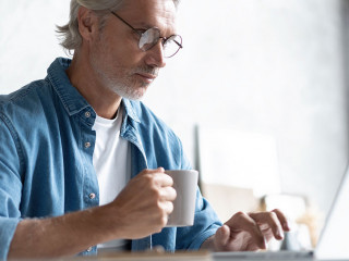 Middle-aged man working from home-office on laptop.