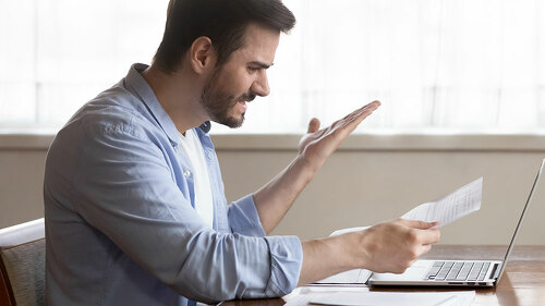 Handsome guy annoyed by paper dismissal notice, document mistake.