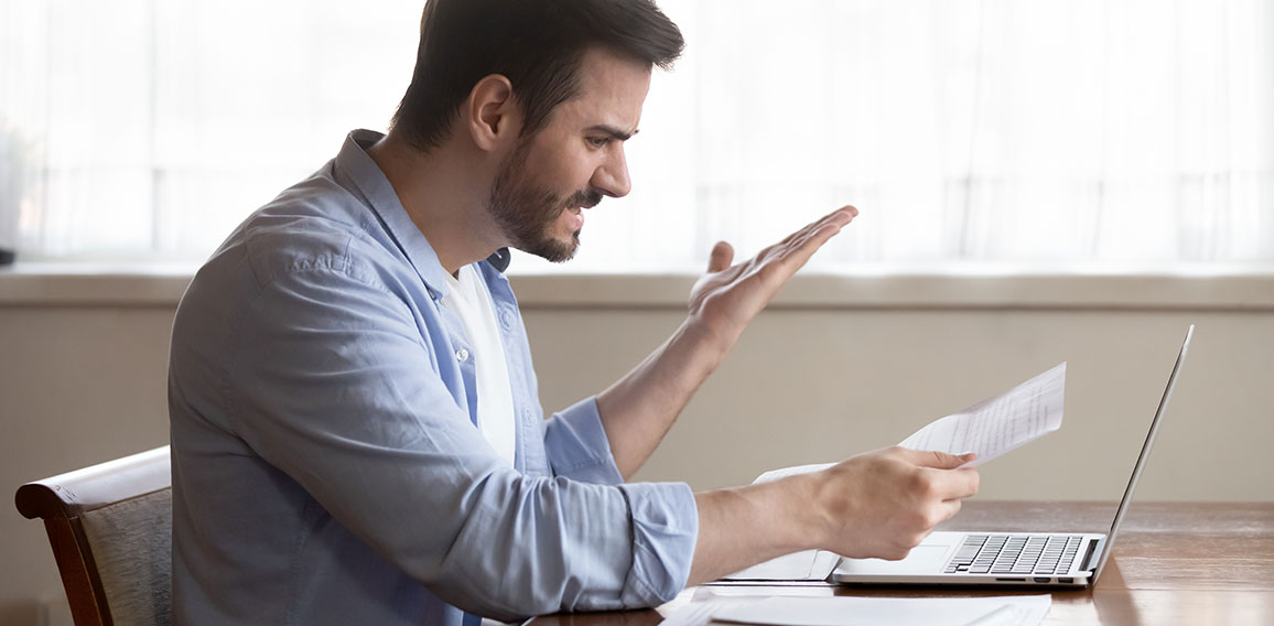 Handsome guy annoyed by paper dismissal notice, document mistake.