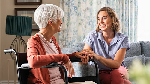 Happy adult woman visiting her elderly mother at home