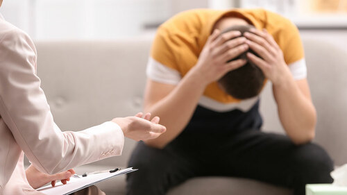 Psychotherapist working with young man in office