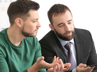 Businessman consulting young man in office