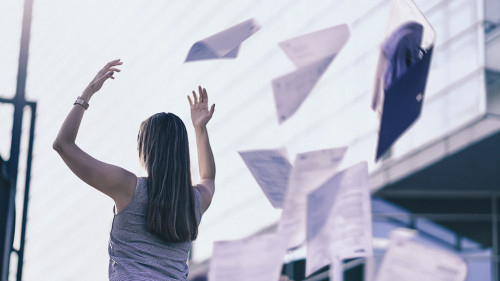 Business woman throwing work papers in the air. Stress from work