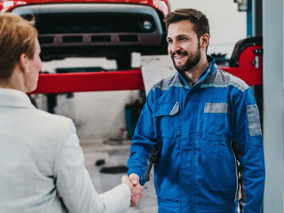 A middle-aged businesswoman in a modern and clean car repair sho
