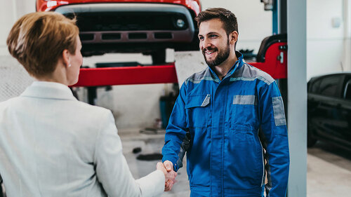 A middle-aged businesswoman in a modern and clean car repair sho