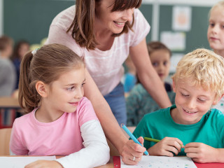 Teacher helping a young boy at school