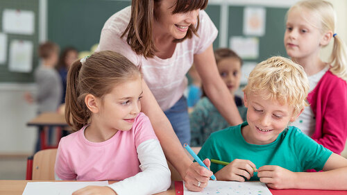 Teacher helping a young boy at school