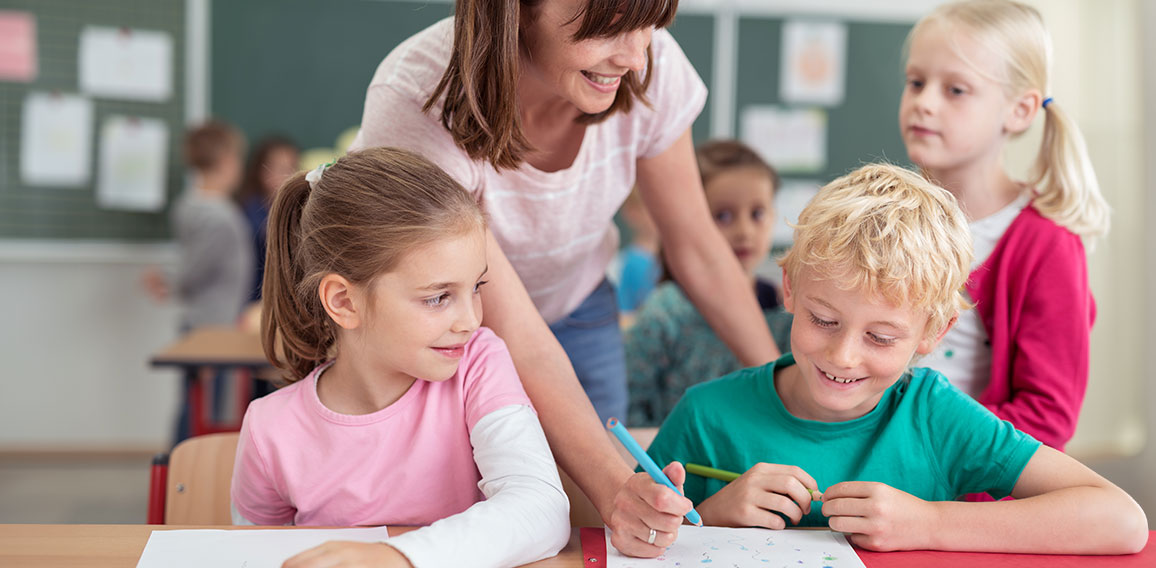 Teacher helping a young boy at school