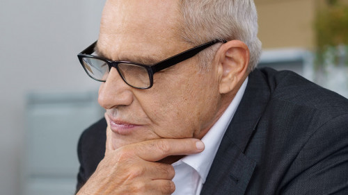 Boss thinking while coworker sits on table