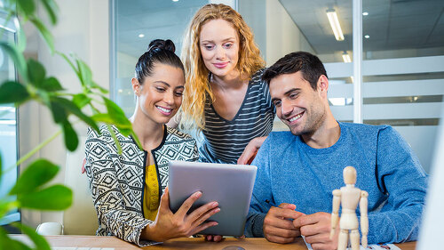 Smiling business team working together with tablet in the office
