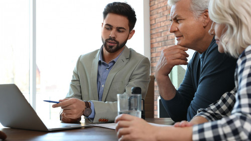 Male notary working with mature couple in office