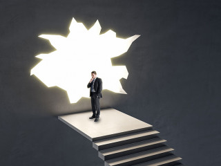Thoughtful businessman on stairs looking out of hole in broken wall into a bright future. Market research, success, tomorrow and crisis ideas concept.