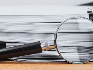 Close-up magnifying glass place on wooden table and search to ed
