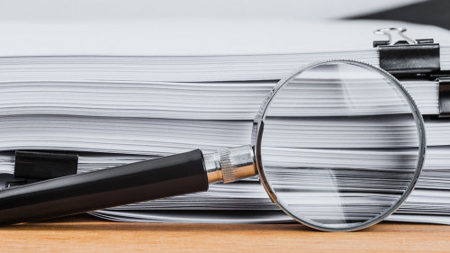 Close-up magnifying glass place on wooden table and search to ed