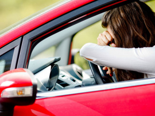 Young woman sitting depressed in car