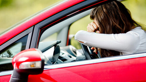 Young woman sitting depressed in car